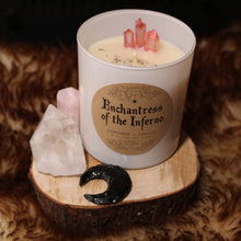 Load image into Gallery viewer, The Enchantress of the Inferno candle by Emerald Hearth in white, photographed next to a piece of pink quartz and a black crescent moon.  The product photography is on top of a fuzzy cloth and the product is on a piece of wood.