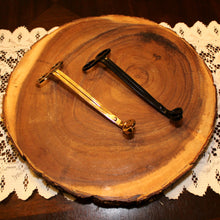 Load image into Gallery viewer, Emerald Hearth candle wick trimmers photographed on a slab of wood.  The two trimmers are in gold and black.