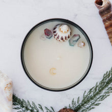 Load image into Gallery viewer, Aerial view of the Siren of the Sea candle by Emerald Hearth.  This candle is adorned with titanium-coated, pastel quartz nestled around a seashell to represent the water element.
