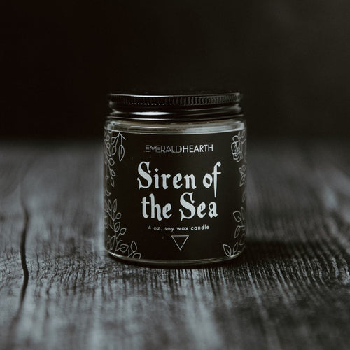 Front of the Siren of the Sea candle.  The candle's packaging is black.  This candle pulls inspiration from the ocean.