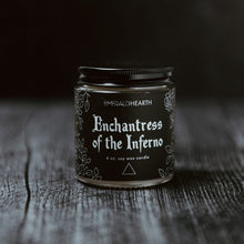 Load image into Gallery viewer, The mini Enchantress of the Inferno candle photographed on wood with a black background.