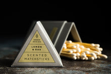 Charger l&#39;image dans la galerie, Image of Lemon &amp; Oak scented match sticks.  The lid of the triangle packaging is in the foreground and in focus.  The background is of the matches which is out of focus.