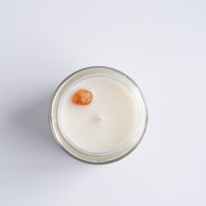 Aerial view of the Lunar Light candle by Emerald Hearth Creations.  The image shows the top of the candle which has a orange/red crystal on the top.