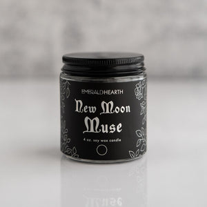 Front view of the New Moon Muse candle by Emerald Hearth.  The candle has black packaging.