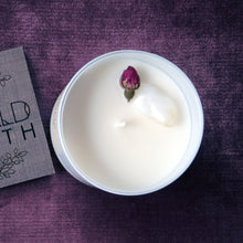 Load image into Gallery viewer, Aerial view of the Goddess Rising Candle by Emerald Hearth.  The top of the candle is white with a rosebud and a quartz crystal in it.